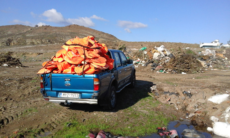 Blauer Pick-up mit orangefarbenen Schwimmwesten auf der Ladefläche.