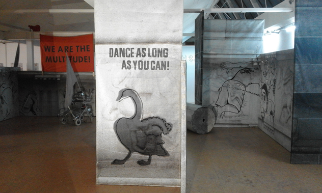 Bedruckte Tafel mit einer Vogelzeichnung und der Aufschrift „DANCE AS LONG AS YOU CAN!“.