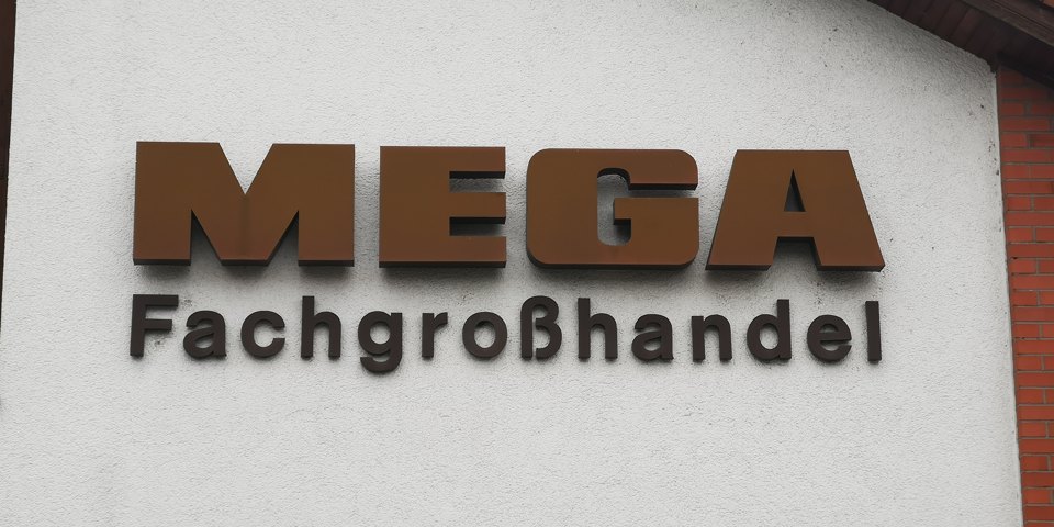 Fassadenschild mit der Aufschrift „MEGA Fachgroßhandel“.