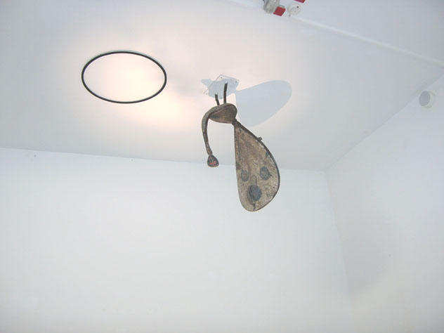 Nahaufnahme des hängenden Objekts mit gebogenen Teilen und einer gemusterten Fläche unter der Decke.