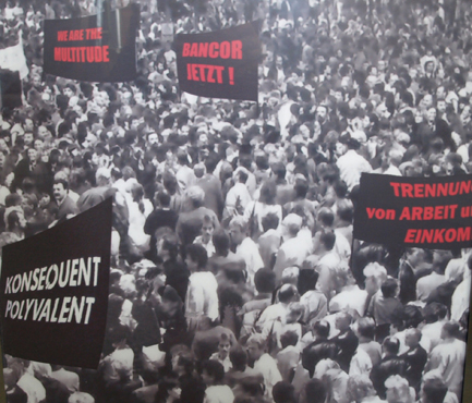 Schwarz-weiße Abbildung einer großen Menschenmenge mit eingefügten schwarzen und roten Schriftplakaten.